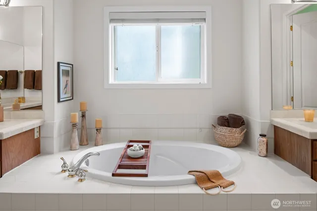 a bathroom with a tub sink and a mirror