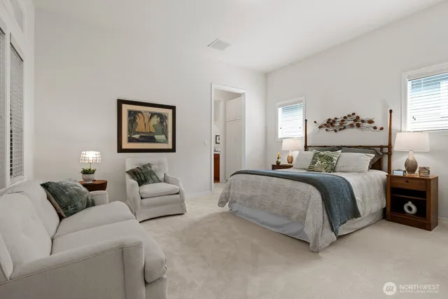 a spacious bedroom with a bed couch and window