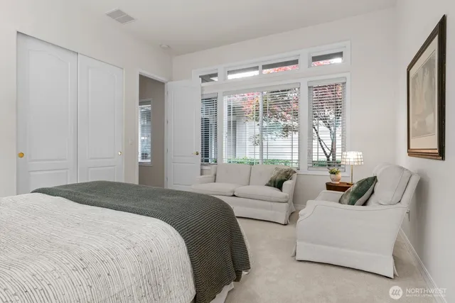 a spacious bedroom with a bed and glass window