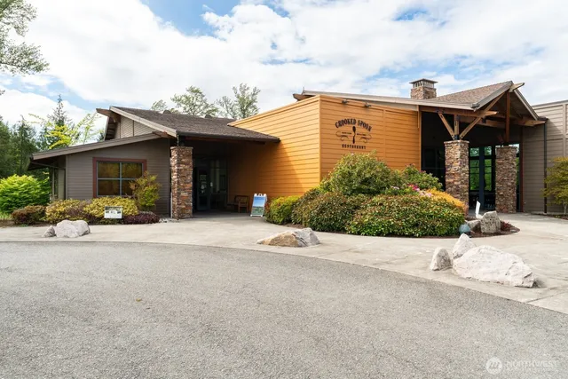 a view of a house with backyard and parking area
