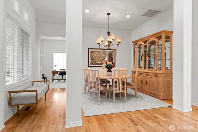 a view of a dining room and livingroom with furniture wooden floor a chandelier