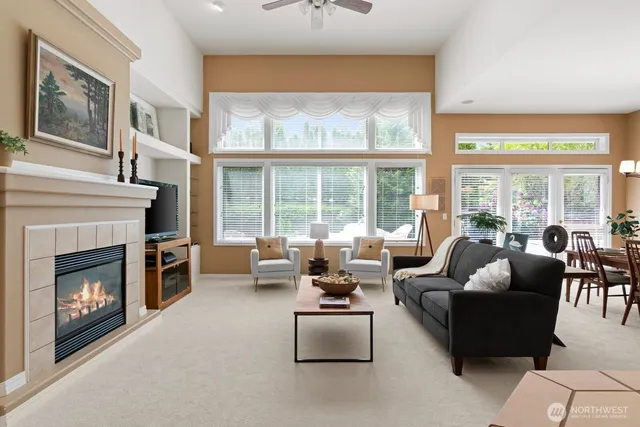 a living room with furniture large window and fireplace