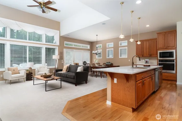 a large kitchen with stainless steel appliances kitchen island granite countertop a sink and a large window