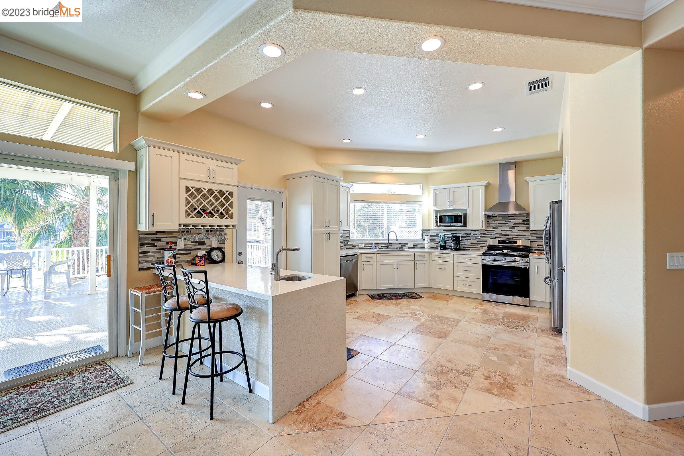 4050 Pier Point, Unit 100 Discovery Bay, CA 94505 - Photo 12 of 60 a view of a kitchen with kitchen island granite countertop a large counter top space a sink stainless steel appliances and cabinets