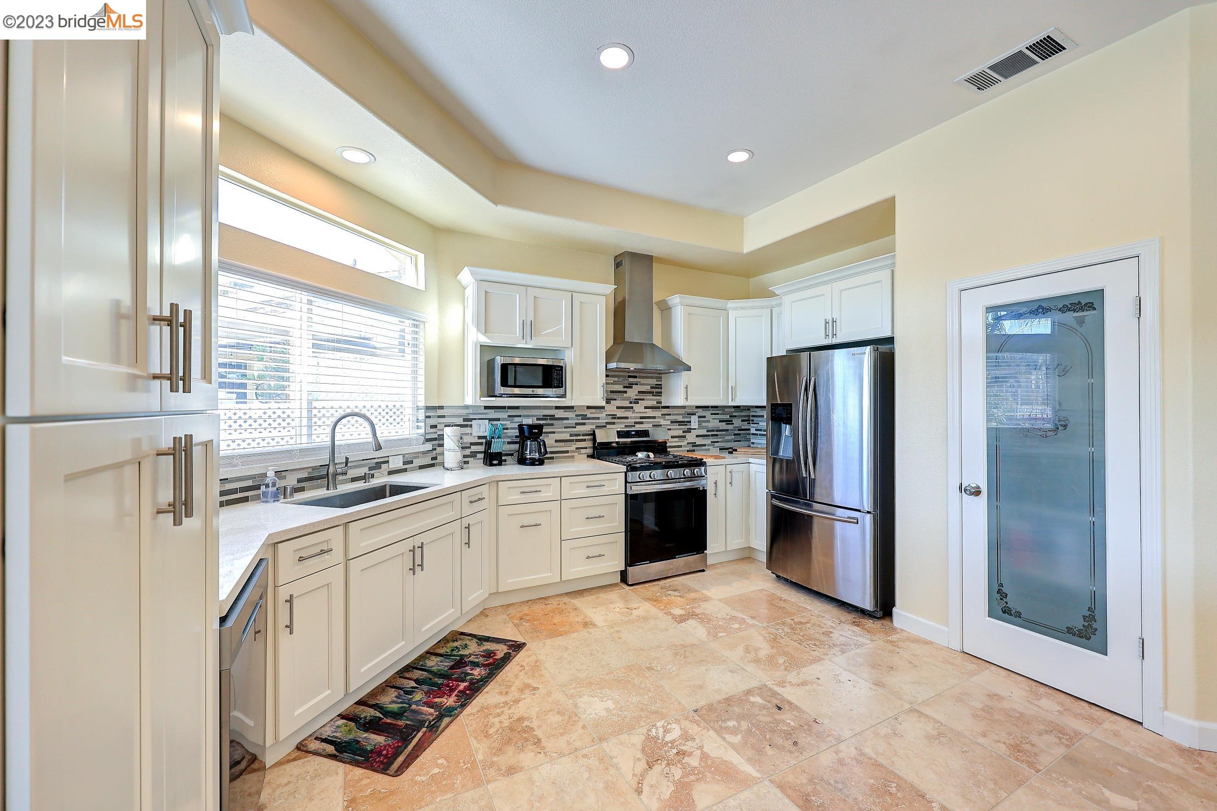 4050 Pier Point, Unit 100 Discovery Bay, CA 94505 - Photo 13 of 60 a kitchen with refrigerator a sink and a stove