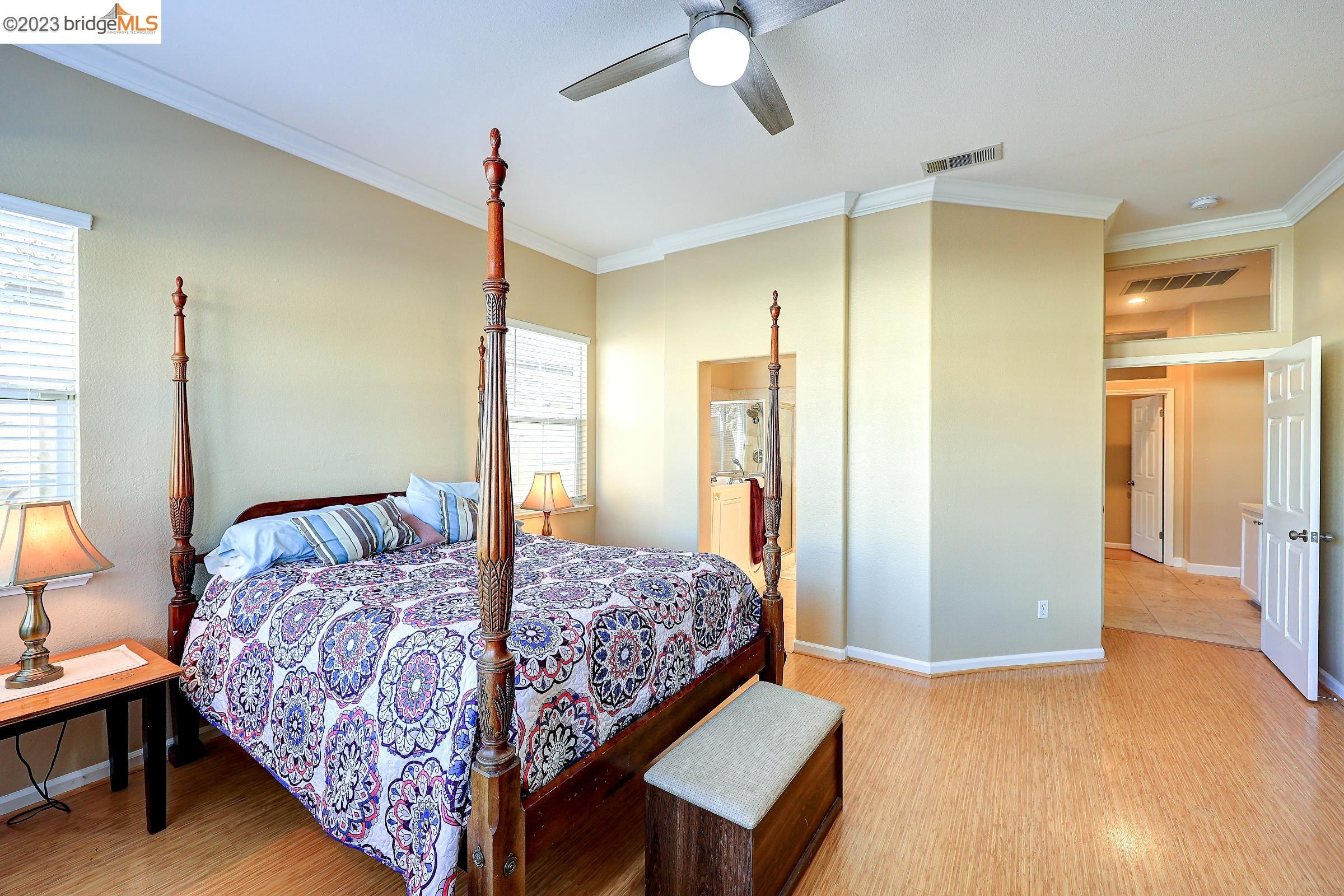 4050 Pier Point, Unit 100 Discovery Bay, CA 94505 - Photo 25 of 60 a bedroom with a bed a dresser and a chandelier