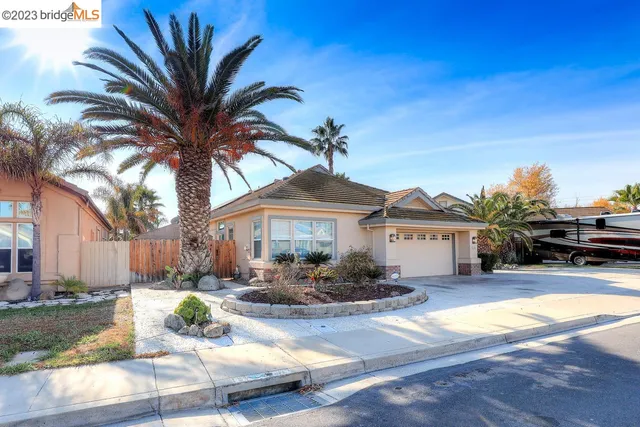 a view of a house with a yard and palm trees