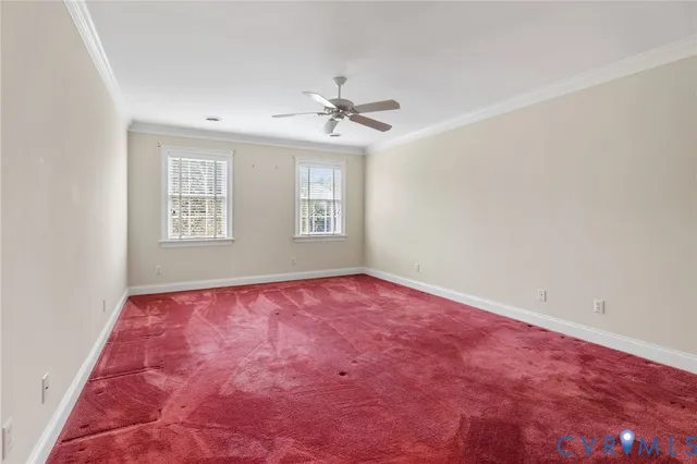 an empty room with windows and ceiling fan