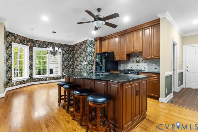 a kitchen with stainless steel appliances granite countertop a sink stove and wooden cabinets