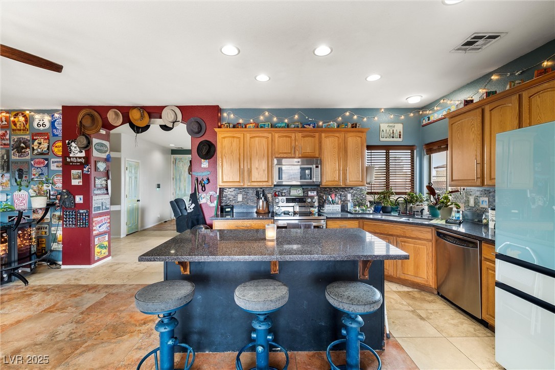1131 South Blagg Road Pahrump, NV 89048 - Photo 11 of 30 Kitchen with a breakfast bar area, a center island, a sink, visible vents, and appliances with stainless steel finishes