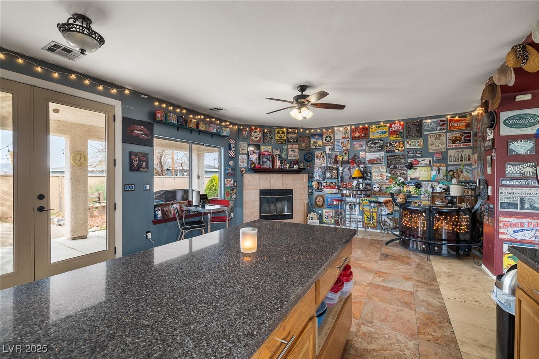 1131 South Blagg Road Pahrump, NV 89048 - Photo 13 of 30 Kitchen with a fireplace, ceiling fan, visible vents, and french doors