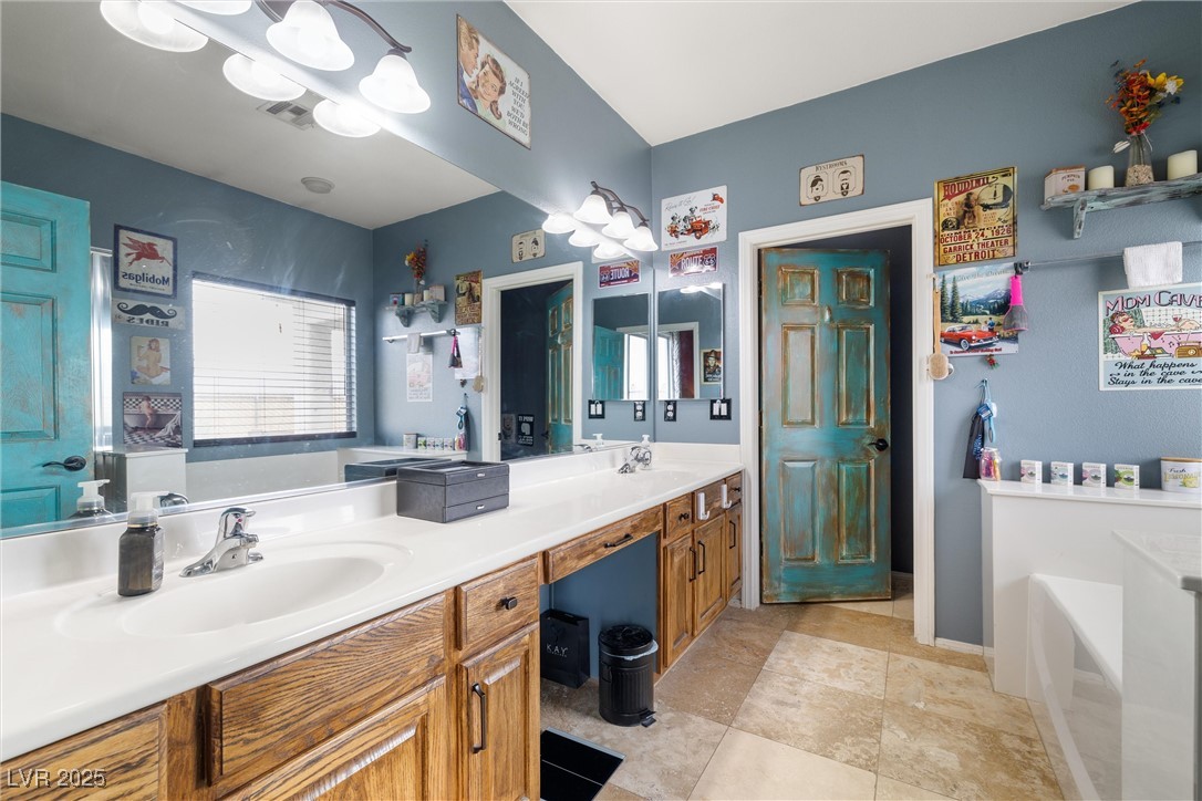 1131 South Blagg Road Pahrump, NV 89048 - Photo 18 of 30 Bathroom featuring double vanity, a sink, visible vents, and a bath