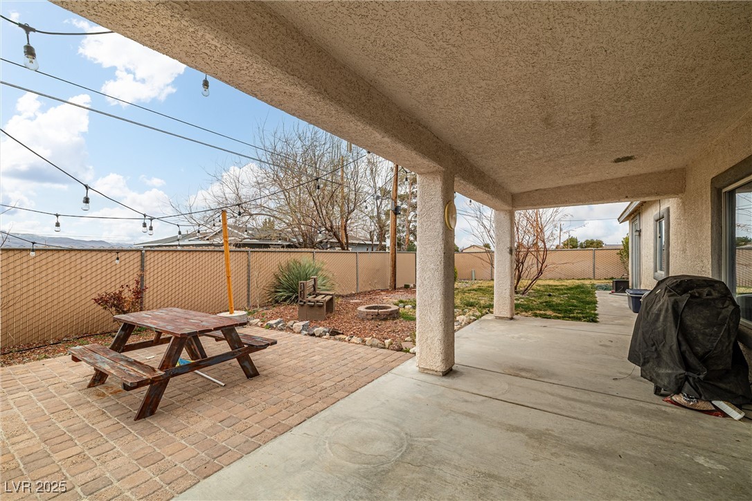 1131 South Blagg Road Pahrump, NV 89048 - Photo 27 of 30 View of patio / terrace featuring an outdoor fire pit, a fenced backyard, and outdoor dining area