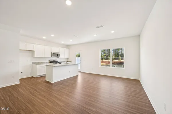 a kitchen with granite countertop white cabinets and stainless steel appliances