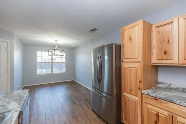a kitchen with stainless steel appliances granite countertop a refrigerator and a stove top oven