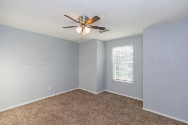 an empty room with windows and fan