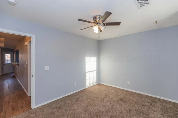 a view of a big room with wooden floor and windows