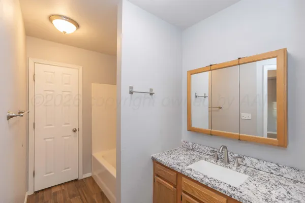 a bathroom with a granite countertop sink and a mirror