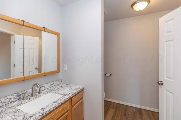 a bathroom with a granite countertop sink and a mirror
