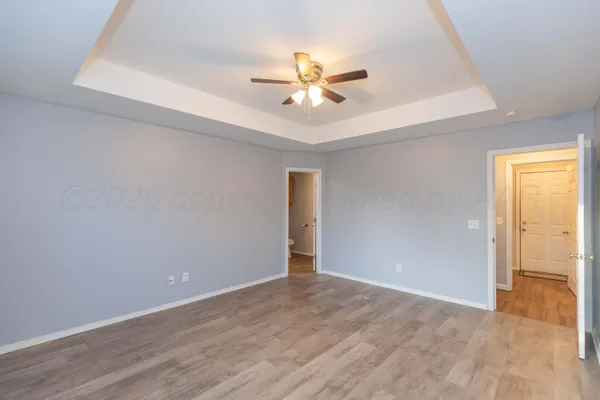 a view of a room with a ceiling fan and wooden floor