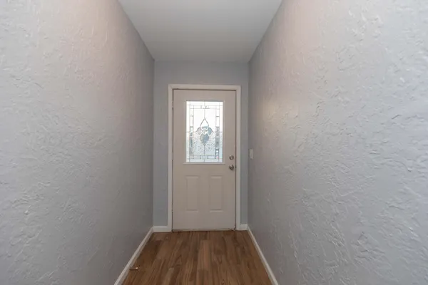 a view of a small space with wooden floor and a window