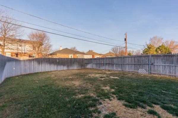 a view of a backyard with wooden fence