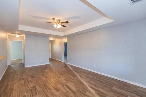 a view of an empty room with wooden floor