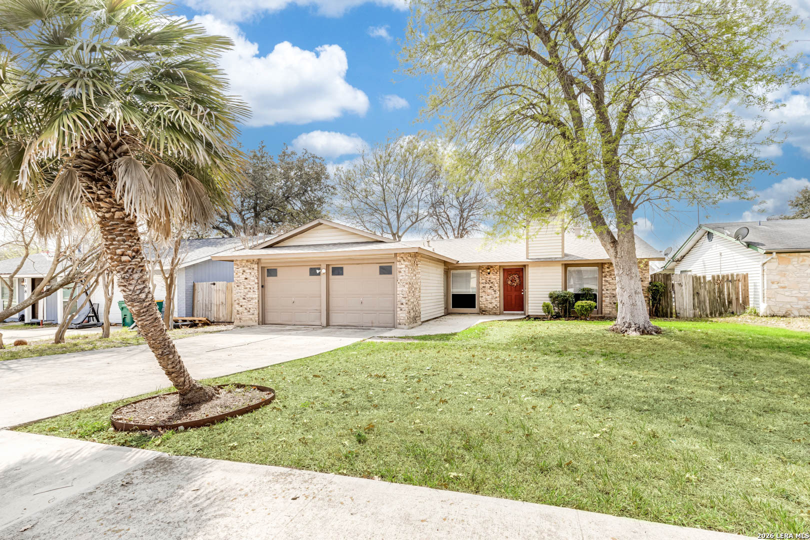 a front view of a house with a yard and trees