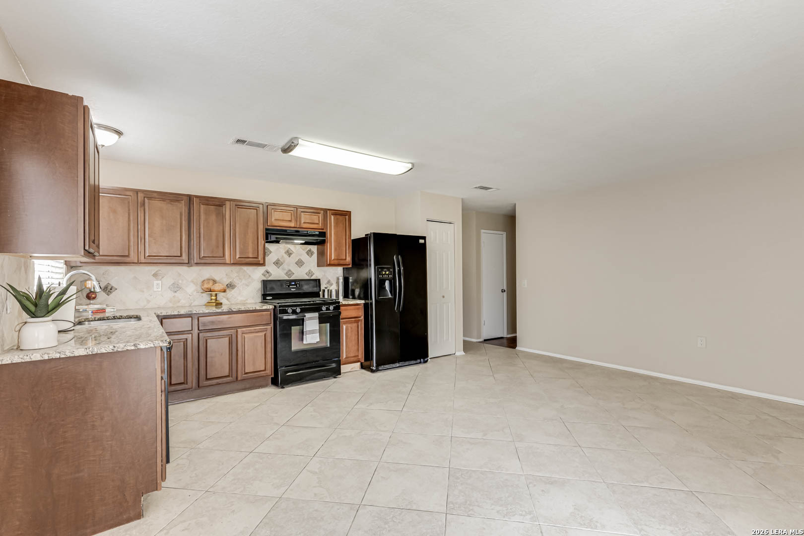 112 Friendswood Path Universal City, TX 78148 - Photo 11 of 31 a kitchen with stainless steel appliances granite countertop a refrigerator oven a sink dishwasher and white cabinets with wooden floor