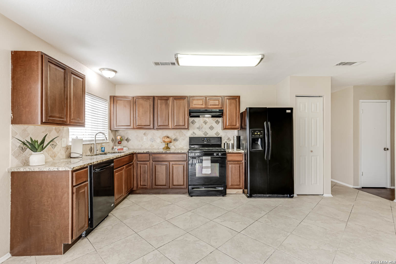 112 Friendswood Path Universal City, TX 78148 - Photo 12 of 31 a kitchen with stainless steel appliances granite countertop a refrigerator stove and sink