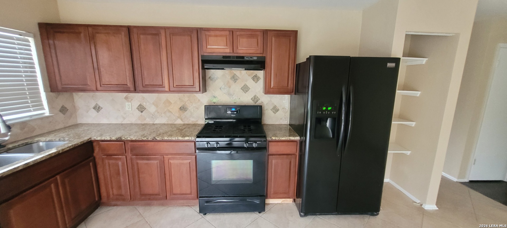 112 Friendswood Path Universal City, TX 78148 - Photo 3 of 8 a kitchen with a refrigerator and a sink