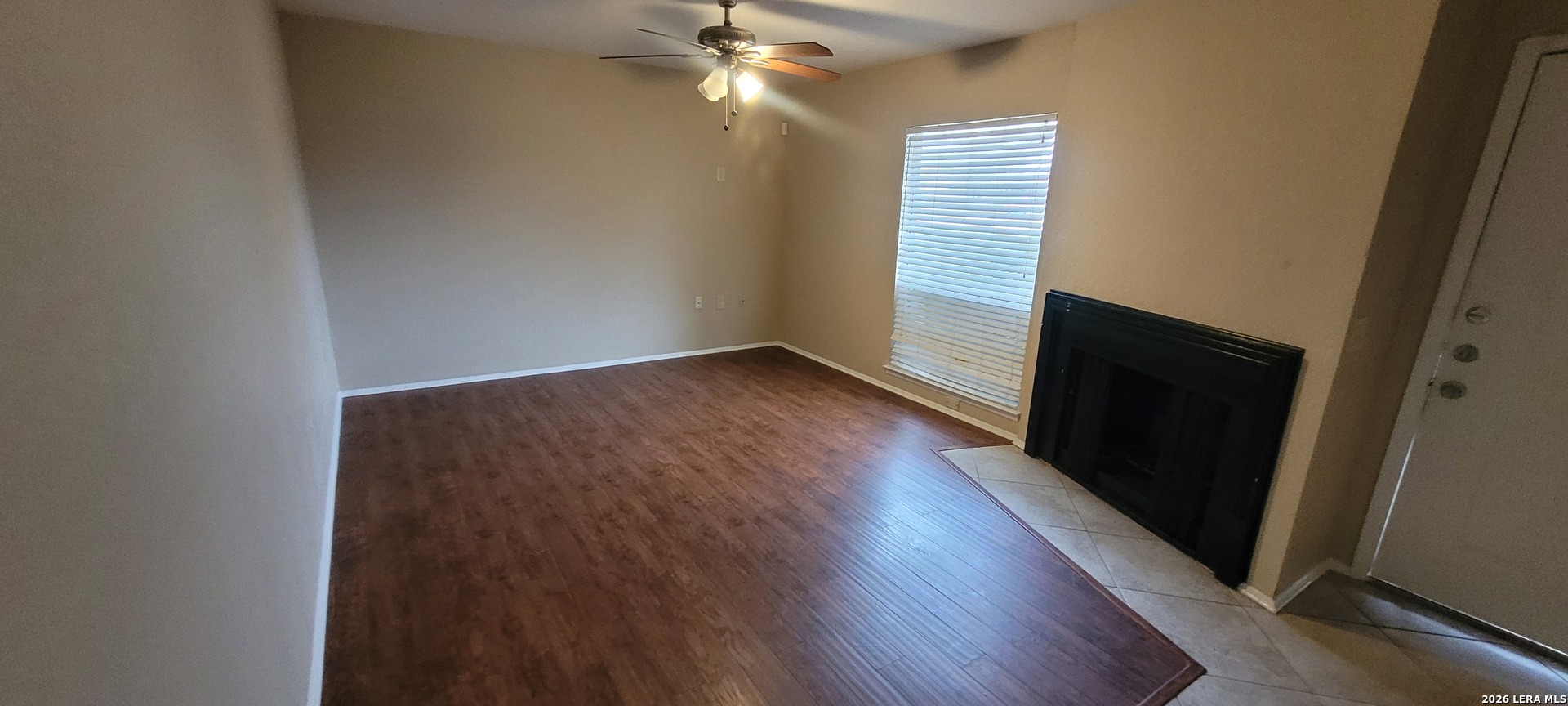 112 Friendswood Path Universal City, TX 78148 - Photo 4 of 8 an empty room with wooden floor and windows