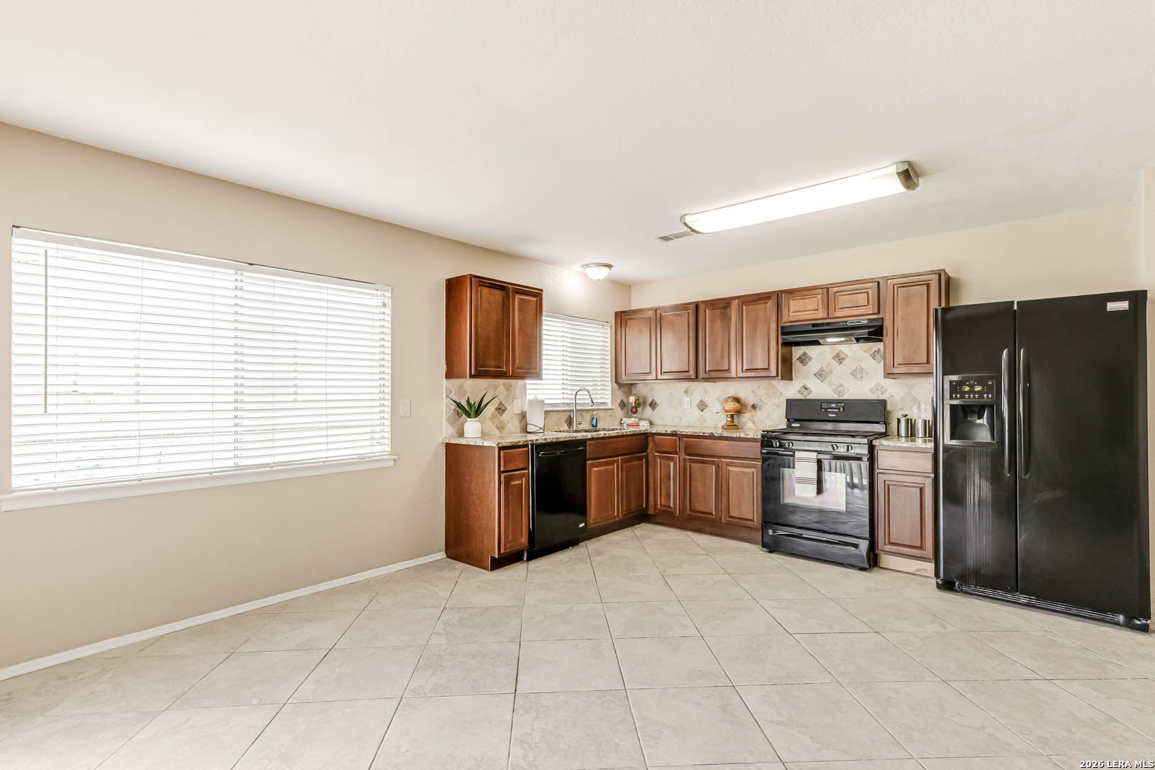 112 Friendswood Path Universal City, TX 78148 - Photo 10 of 31 a large kitchen with a stove a refrigerator a sink dishwasher with a oven and cabinets