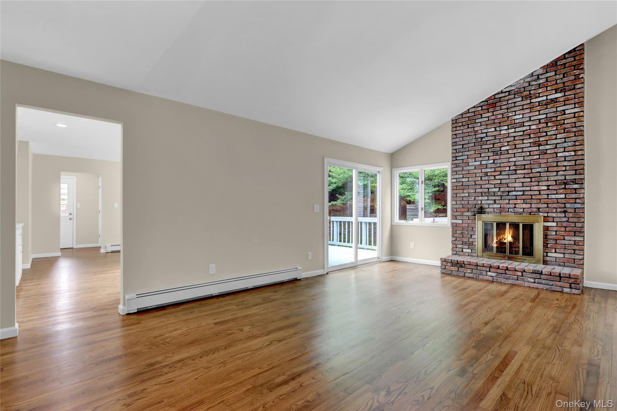 181 Wading River Hollow Road Ridge, NY 11961 - Photo 11 of 24 an empty room with wooden floor and fireplace