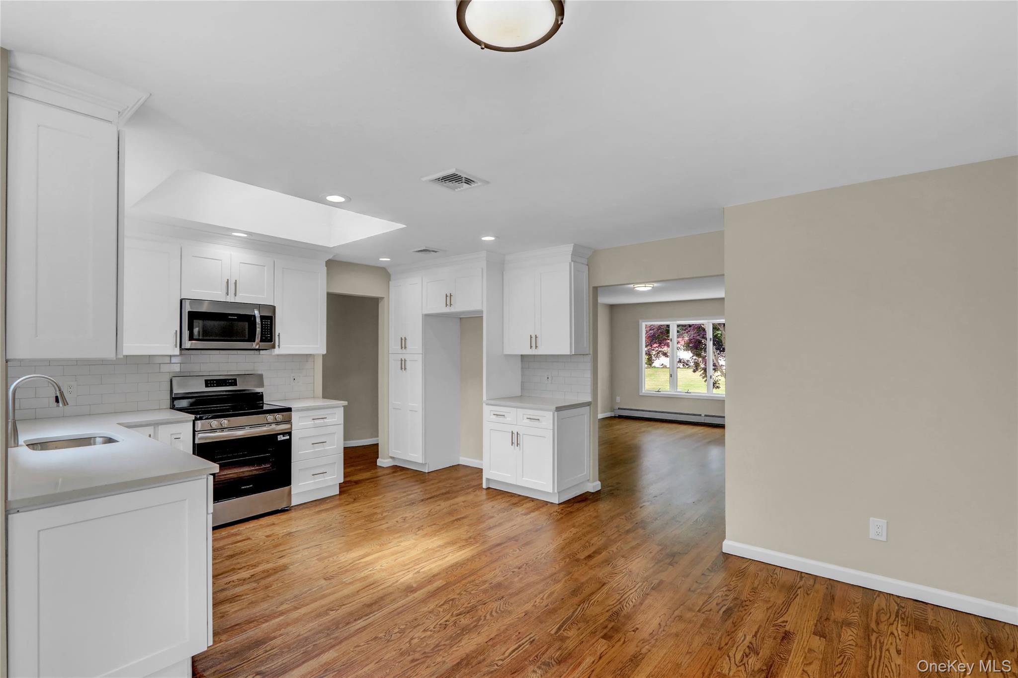 181 Wading River Hollow Road Ridge, NY 11961 - Photo 7 of 24 a kitchen with a refrigerator and a stove top oven