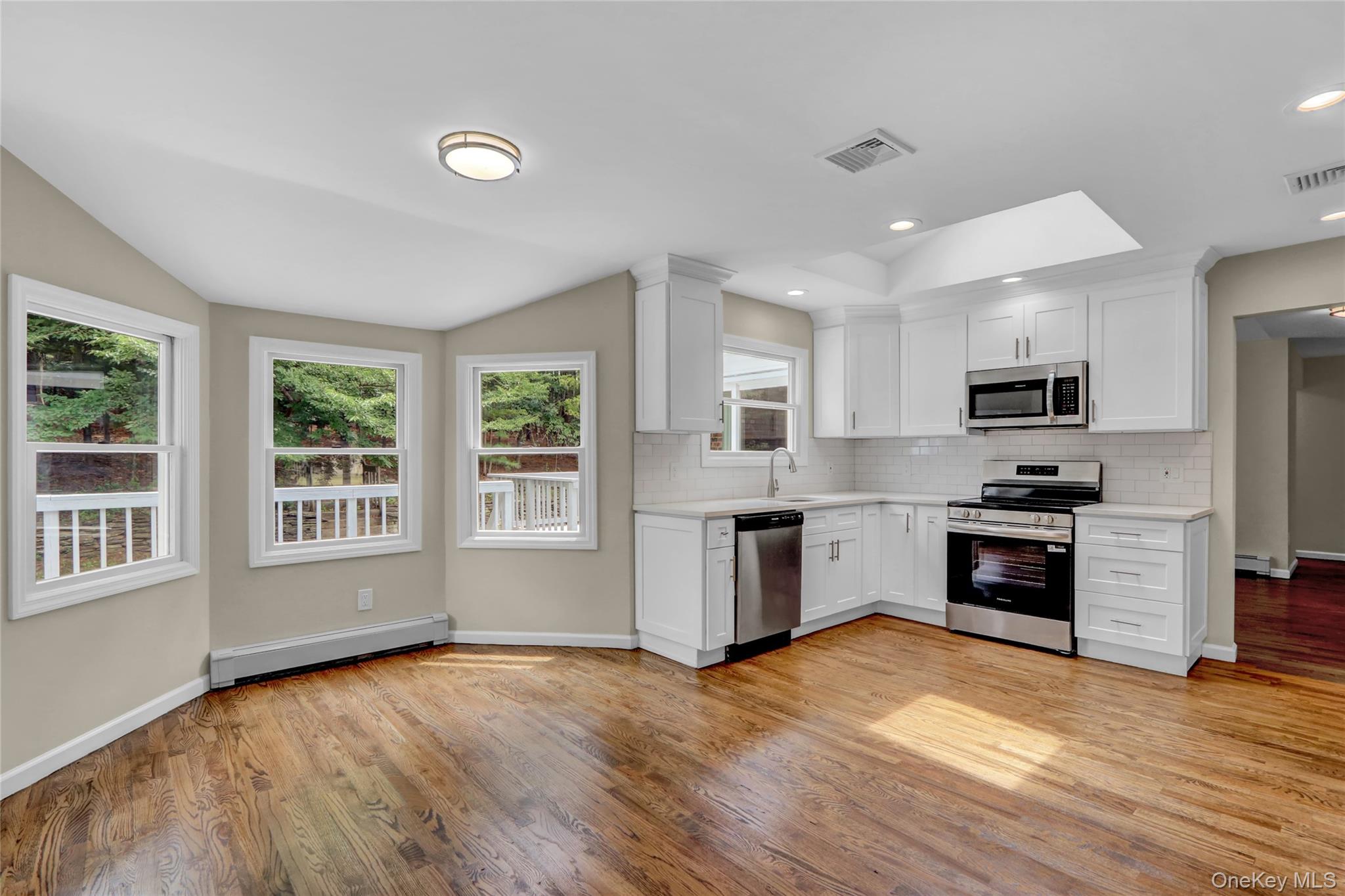 181 Wading River Hollow Road Ridge, NY 11961 - Photo 9 of 24 a kitchen with granite countertop a stove top oven and refrigerator