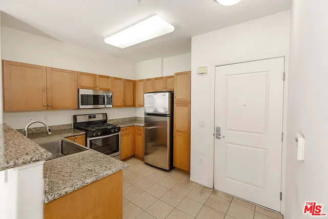 a kitchen with granite countertop stainless steel appliances and a refrigerator