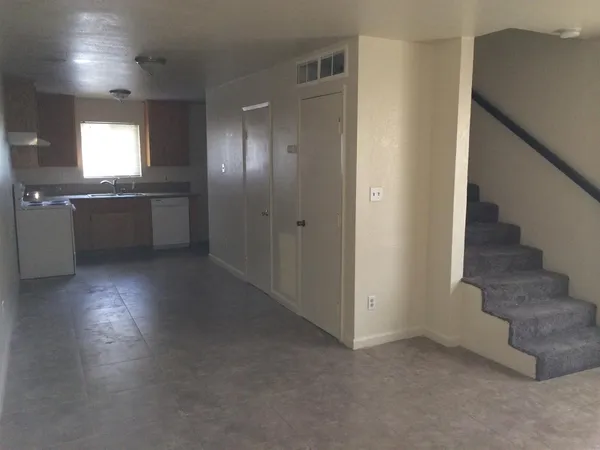 an empty room with windows and fireplace