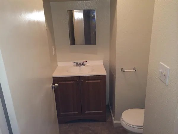 a bathroom with a sink vanity mirror and toilet