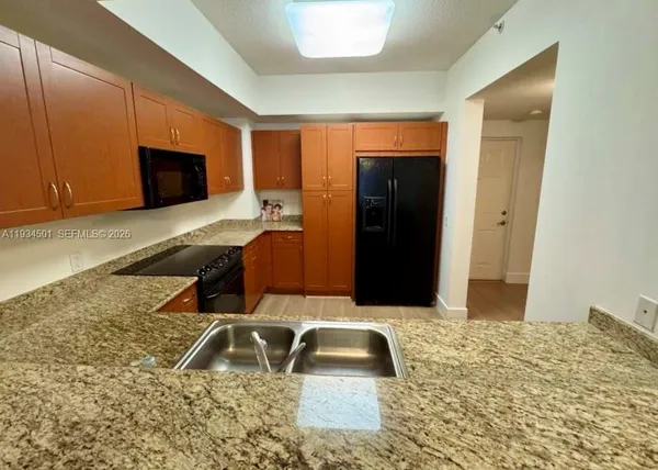 a kitchen with granite countertop a sink and a stove top oven