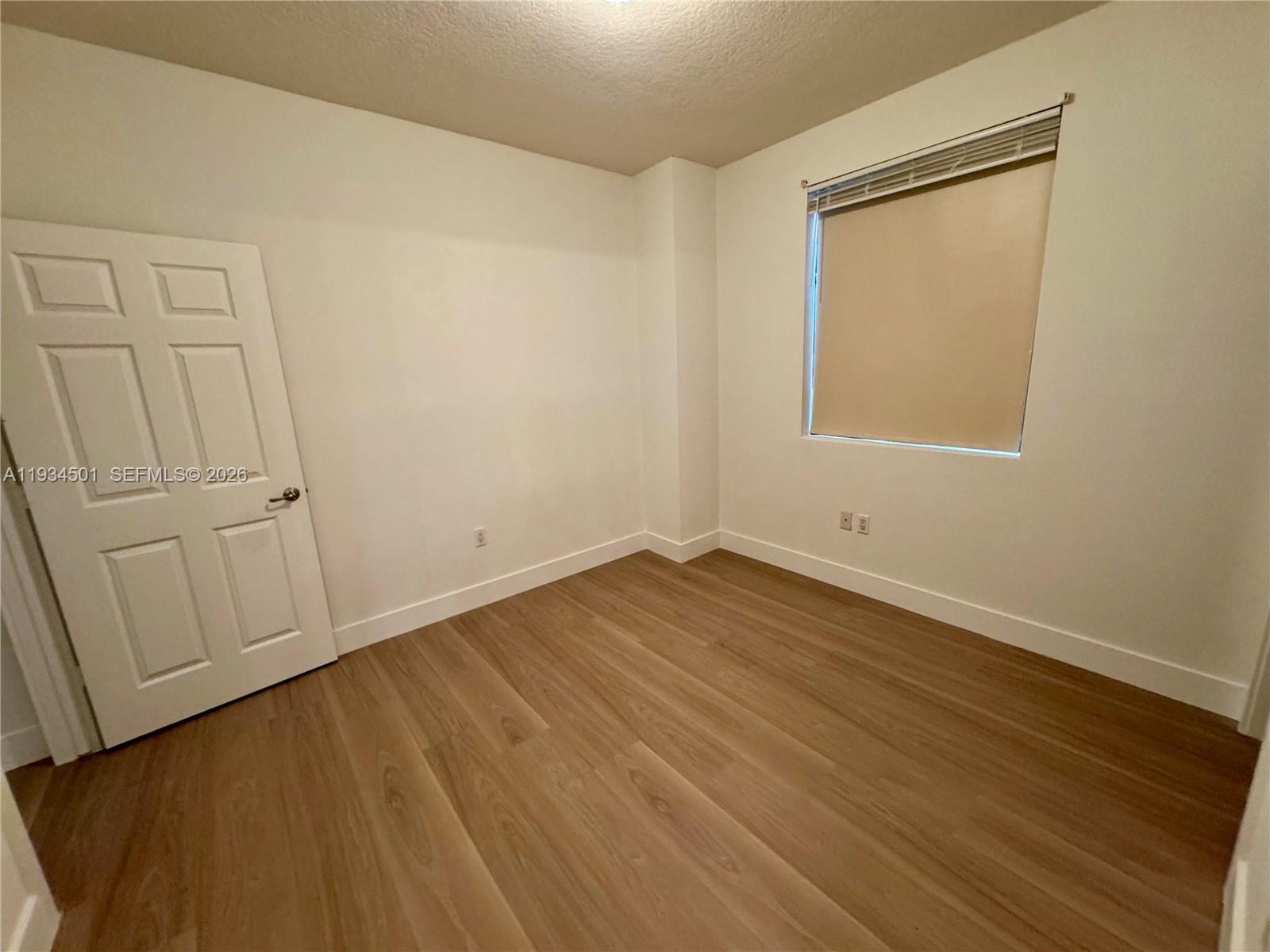 8430 Southwest 8th Street, Unit 201B Miami, FL 33144 - Photo 7 of 14 wooden floor in an empty room