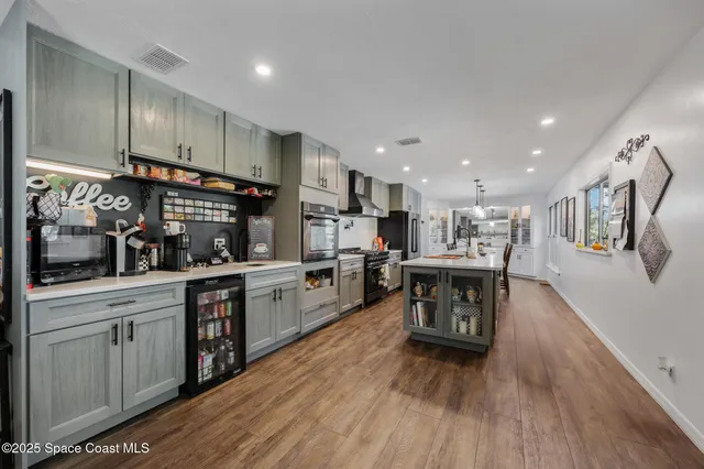 a kitchen with stainless steel appliances granite countertop wooden floors and white cabinets