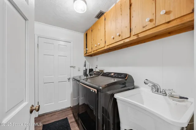 a utility room with sink dryer and washer