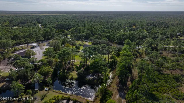 a view of a fountain in front of a house with a big yard