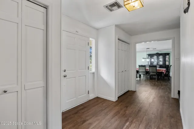 a view of a hallway with wooden floor fireplace and dining room
