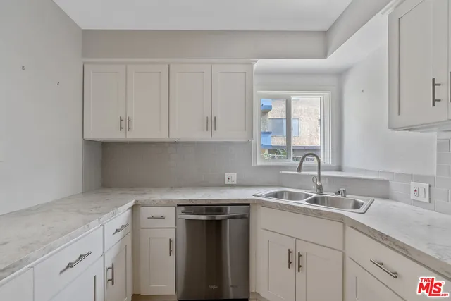 a kitchen with granite countertop white cabinets and a sink