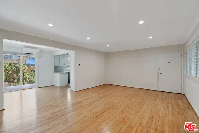 a view of empty room with wooden floor and entryway