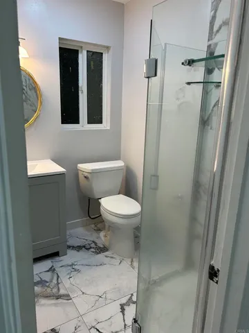 a bathroom with a toilet and a shower