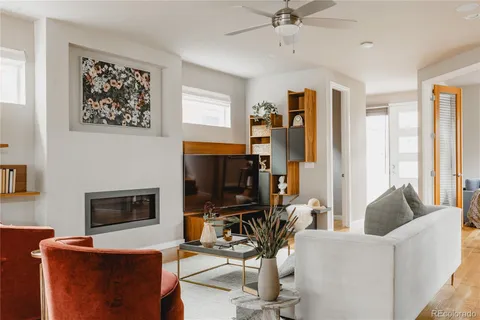 a living room with furniture a flat screen tv and a fireplace