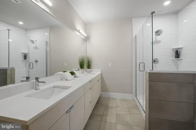 a bathroom with a double vanity sink mirror and shower